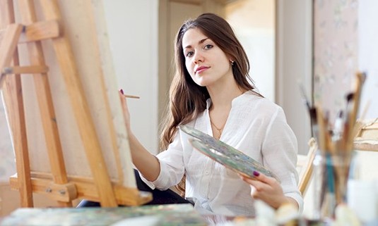 A lady painting a canvas 