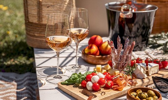 Two glasses of wine and a cheese board.