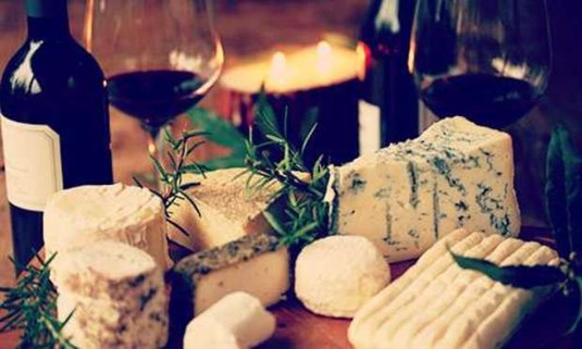 Different cheeses with a glass of wine and candlelight.Discover Bristol Wine and Cheese Tasting with your hen party: