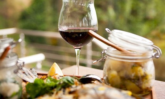 An image of a food board and a glass full of wine.
