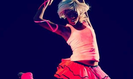 Girl dressed in neon pink and a tutu, jumping. Explore the Lincoln 90s Raver for your hen weekend: