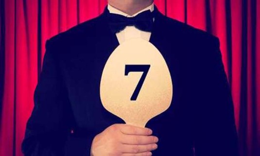 Judge in a tux holds up a seven score. Discover the Lincoln Strictly Come Dancing hen party experience: