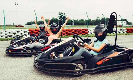 Three ladies taking part in outdoor go karting.