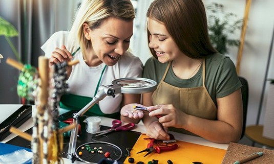 Two ladies enjoying making bracelets together
