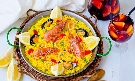 A plate of paella and glass of sangria.